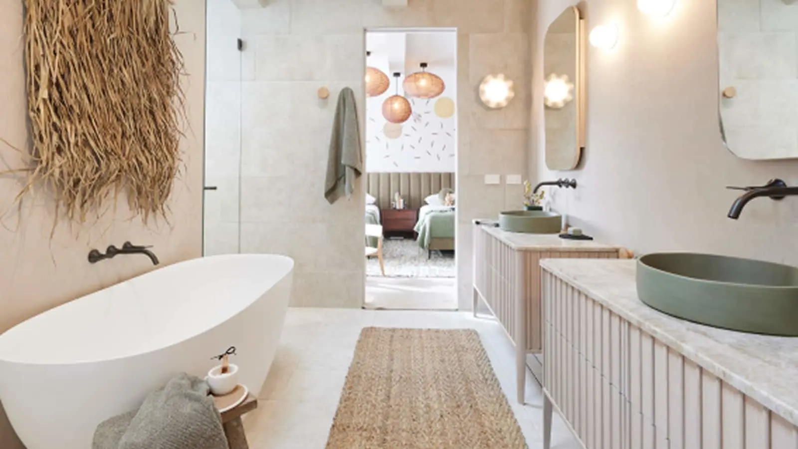 Modern bathroom with freestanding tub, green vessel sinks, natural decor, and view into bedroom with woven pendant lights.