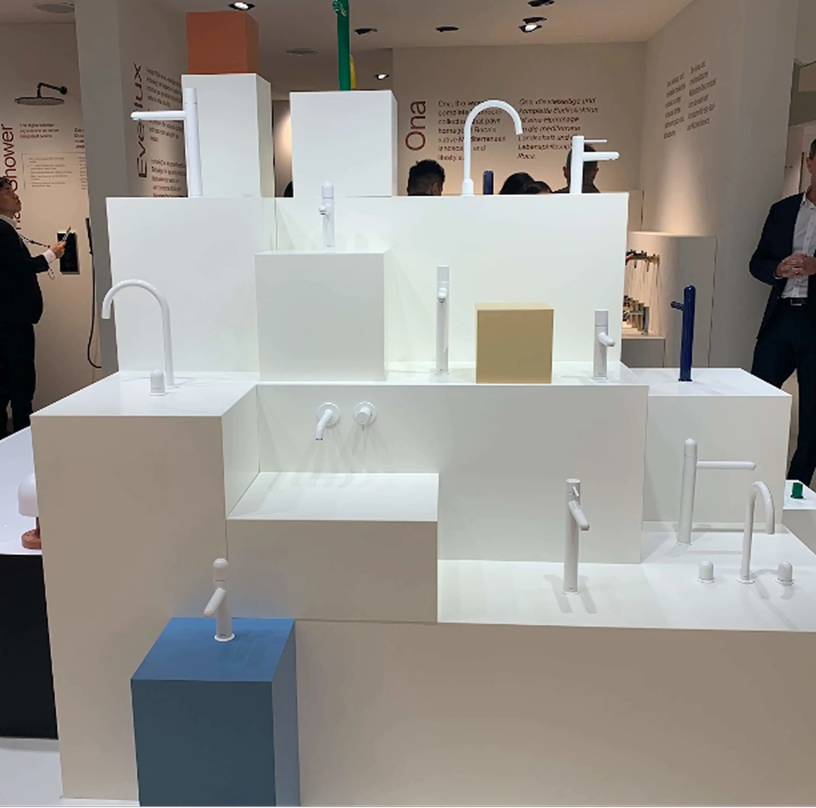 Modern white architectural model displaying various faucet and fixture designs in a showroom exhibition.