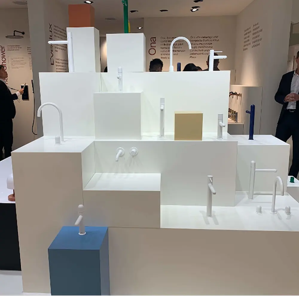 Modern white architectural model displaying various faucet and fixture designs in a showroom exhibition.