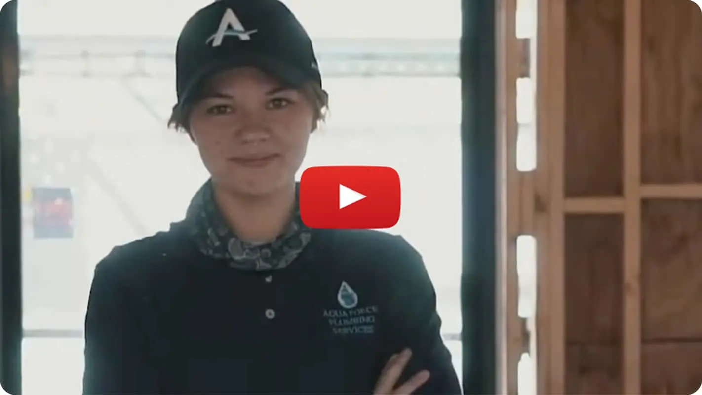 Person in black uniform with cap wearing a patterned neck gaiter, with YouTube play button overlay on the image.