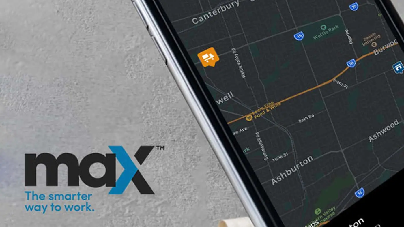 Smartphone displaying a dark mode navigation map with maX logo and tagline "The smarter way to work" on gray surface.