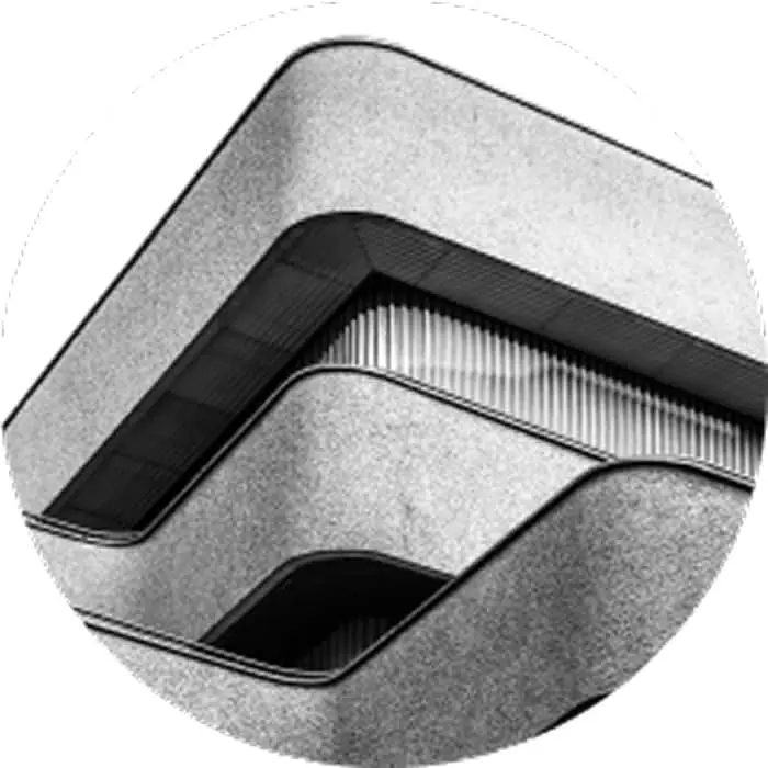 Close-up of modern building architecture with angular concrete features and geometric lines in black and white.