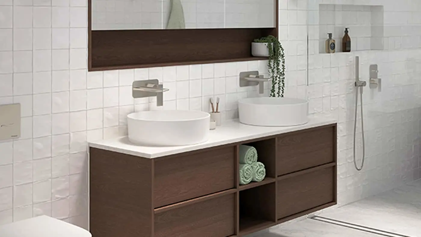 Modern bathroom with white tile walls, dark wood vanity with dual vessel sinks, and wall-mounted faucets.