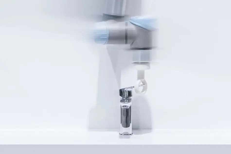 Motion-blurred modern bathroom faucet with chrome finish against white background.