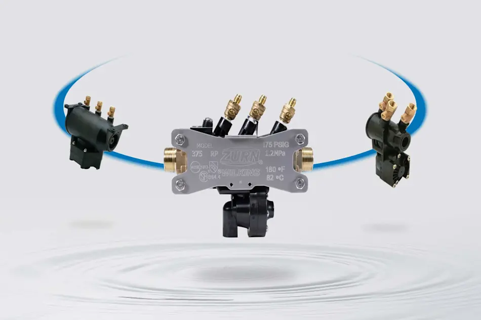 Zurn Wilkins Model 375 pressure regulator with brass fittings and connected valves against a light background.