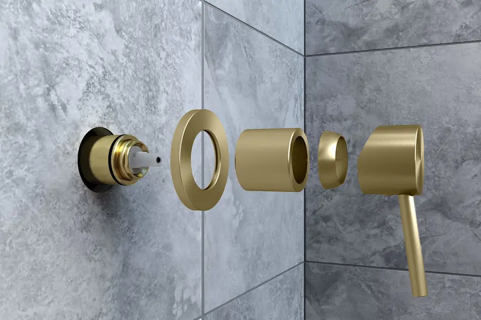 Disassembled brass shower fixture components shown against gray marble tile wall in bathroom installation.