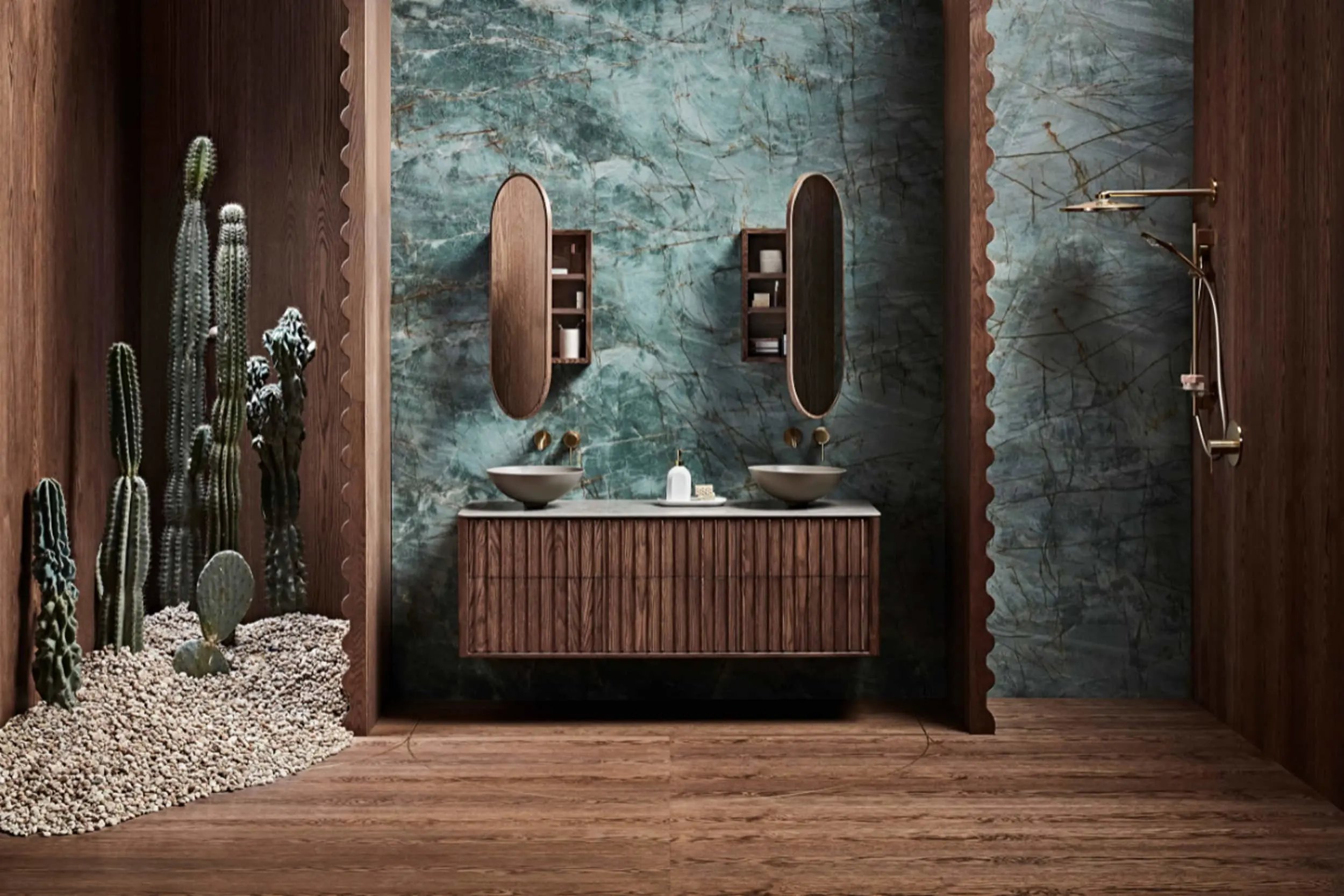 Modern bathroom with teal marble walls, wooden vanity with dual sinks, oval mirrors, and cacti in pebble bed.