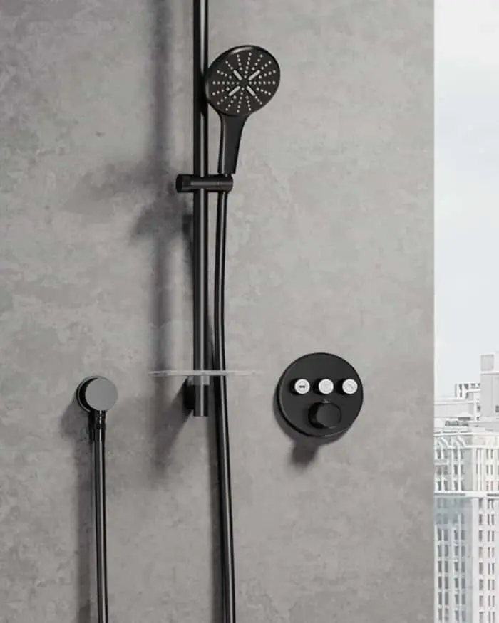 Modern black shower head and controls mounted on a gray concrete wall with city view visible through window.