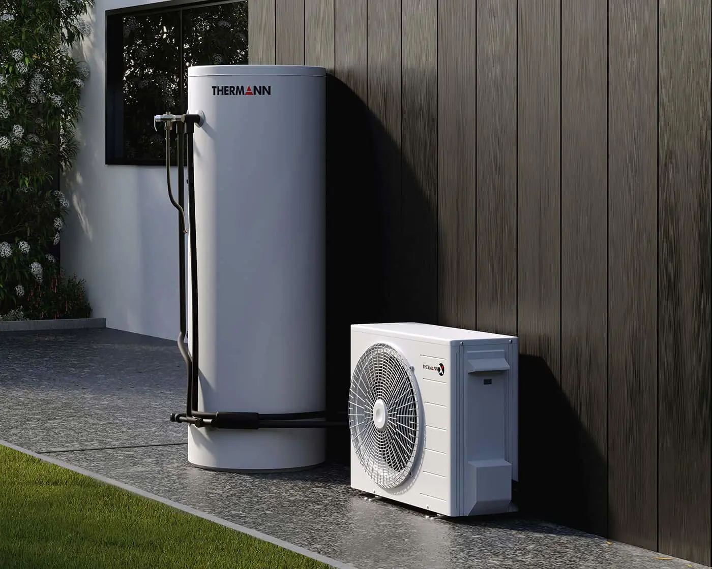 Thermann heat pump system with tall white tank and outdoor condenser unit installed against wooden wall exterior.