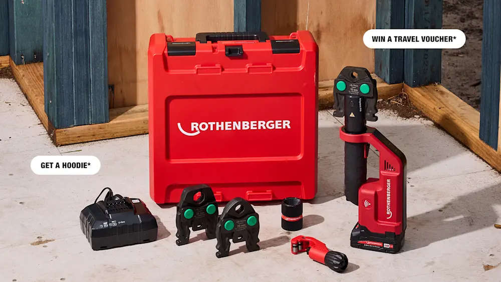 Rothenberger red tool kit with press tool, jaw attachments, battery charger, and red carry case on a concrete floor.