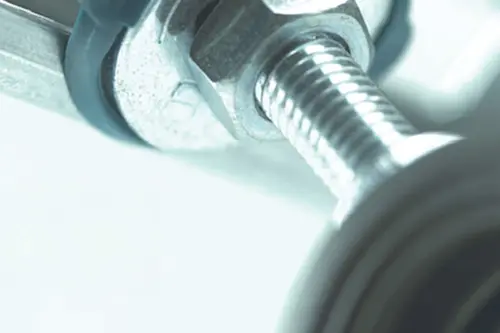 Close-up of a metal bolt and nut with threaded shaft in cool blue-tinted lighting.