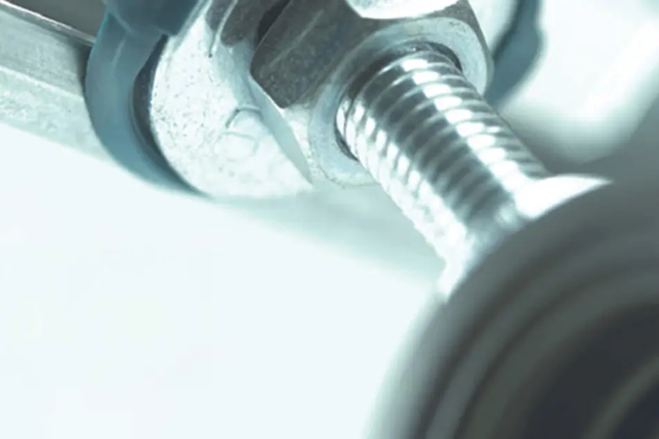 Close-up of a metal bolt and nut with threaded shaft in cool blue-tinted lighting.