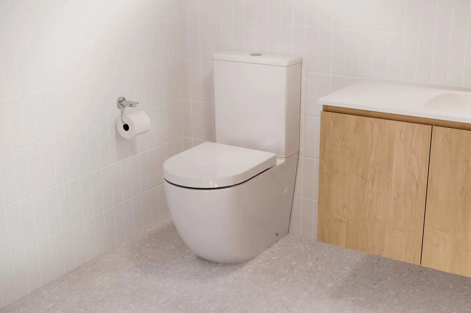 Modern white bathroom with toilet, wooden vanity cabinet, white tiled walls and speckled gray floor.