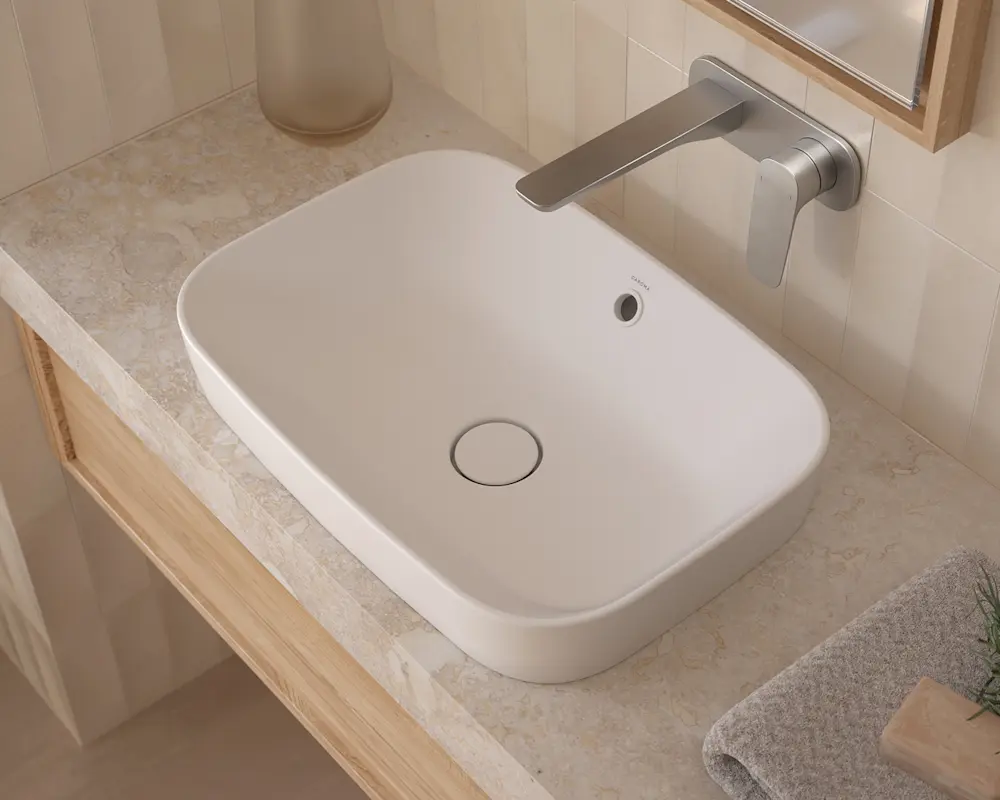 Modern white rectangular vessel sink with wall-mounted brushed nickel faucet on marble countertop with wooden trim.