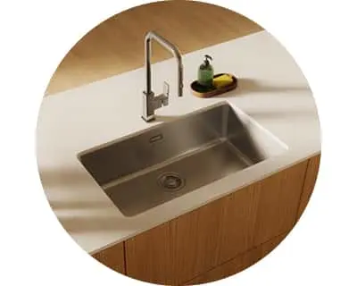 Modern stainless steel kitchen sink with tall faucet on white countertop with wooden cabinets below