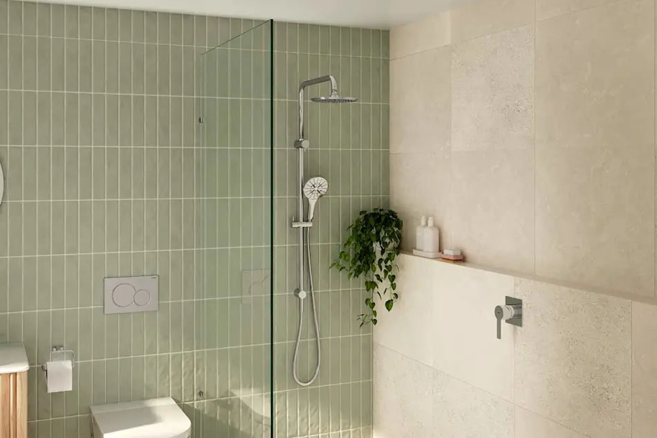 Modern bathroom with sage green vertical tiles, glass shower panel, chrome fixtures, and small potted plant on a built-in shelf.