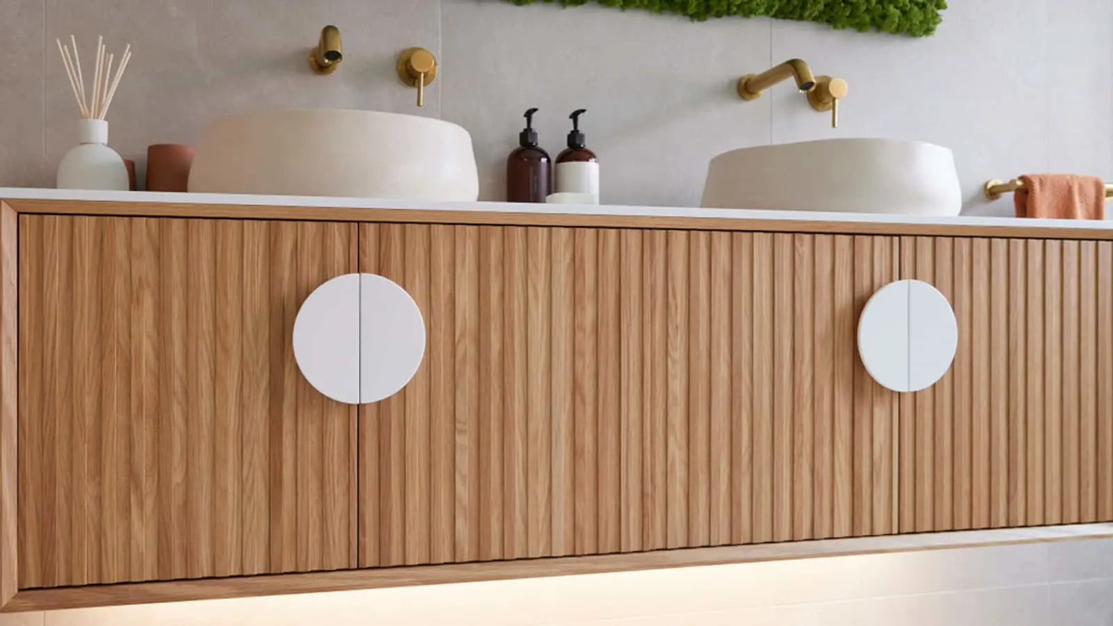 Modern bathroom with wooden vanity featuring two white vessel sinks, brass fixtures, and minimalist decor.
