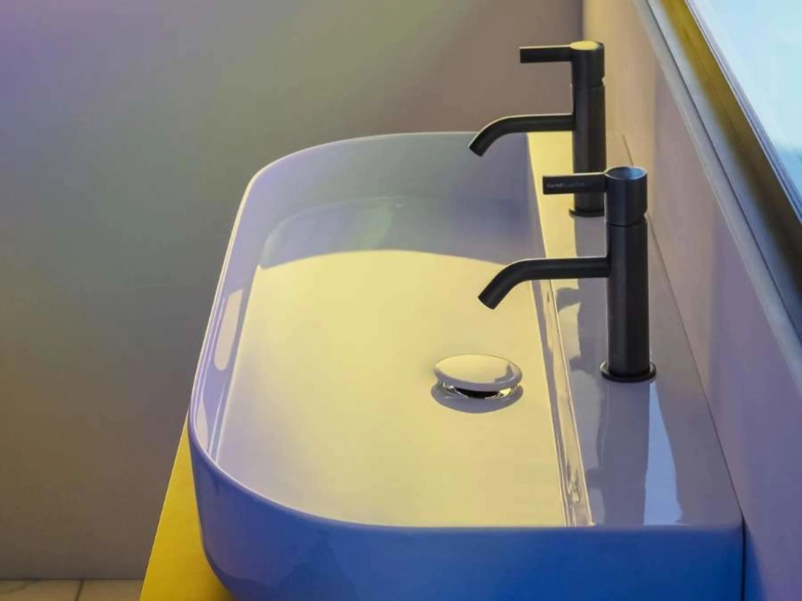 Modern white oval bathroom sink with matte black faucet mounted on a yellow countertop.