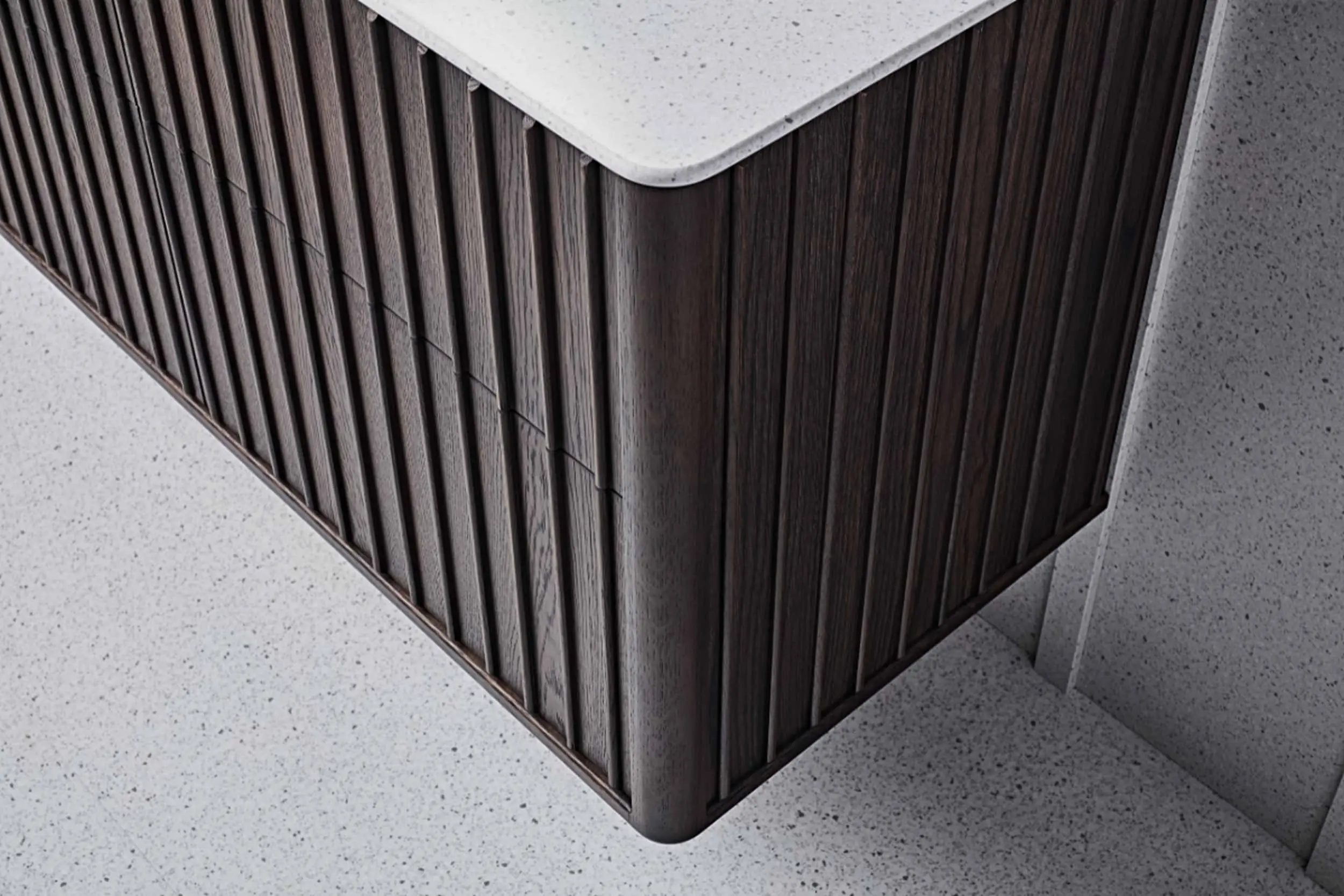 Modern cabinet with dark wood vertical slats and white stone countertop on speckled light floor.