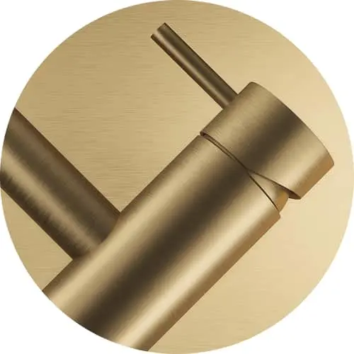 Close-up of a brushed gold bathroom fixture with cylindrical handle against a gold circular background.