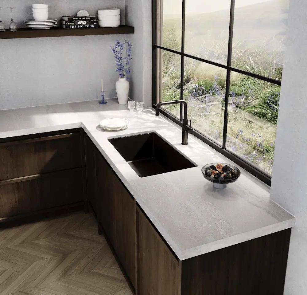 Modern kitchen with dark wood cabinets, white countertop, black sink, and large window overlooking wild grasses.