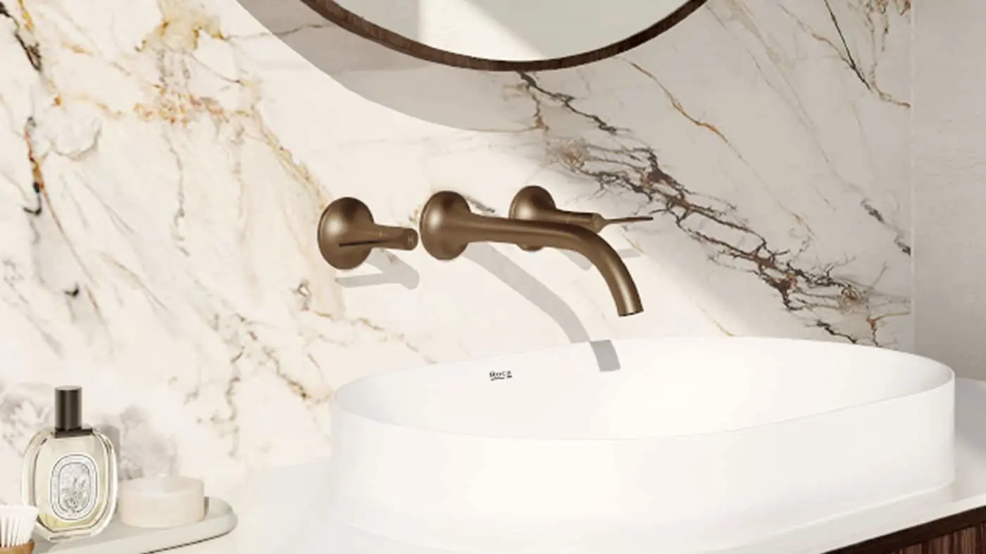 Modern bathroom with bronze wall-mounted faucet, white vessel sink, and marble backsplash with veining patterns.