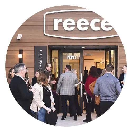 Group of people entering Reece kitchen showroom with wooden facade and illuminated signage