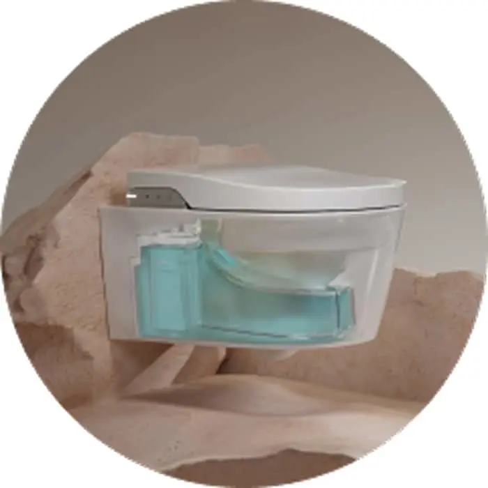 Clear toilet pan with blue water in cistern, sitting on beige fabric, displayed in circular frame.