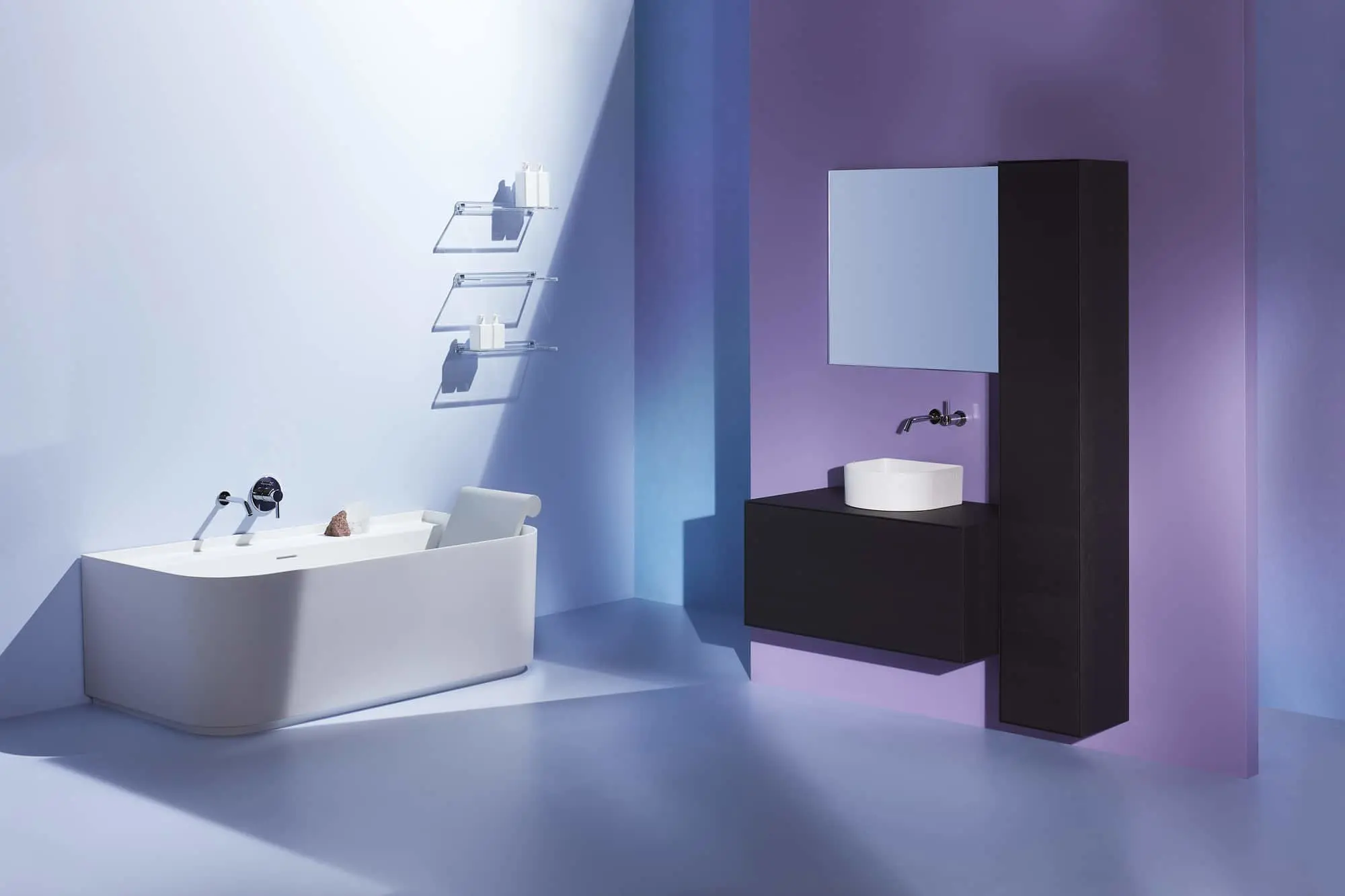 Modern bathroom with white freestanding bathtub, black wall-mounted vanity, and purple accent wall with glass shelving.