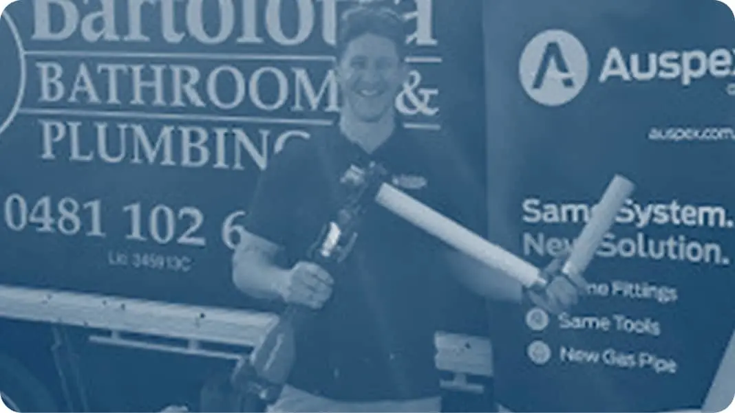 Blue-tinted image showing plumber holding plumbing tools.