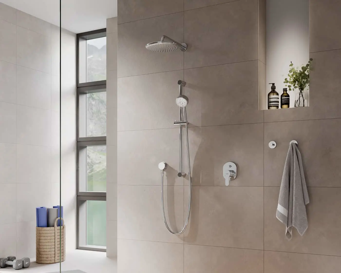 Modern bathroom with beige tile walls, rainfall showerhead, handheld shower, wall niche with toiletries, and tall window.
