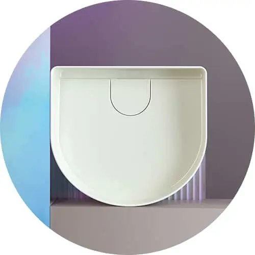 White D-shaped bathroom sink or basin viewed from above against a purple background in a circular frame.