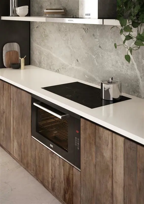 Modern kitchen with wooden cabinets, white countertop, black induction cooktop, built-in oven, and marble backsplash.