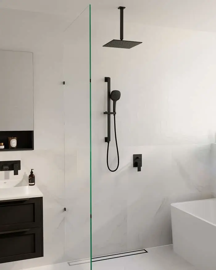 Modern bathroom with white walls, glass shower partition, black fixtures including ceiling-mounted showerhead and handheld.