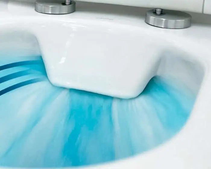Close-up of a white toilet bowl with blue water swirling inside, showing two metal mounting bolts on the tank.