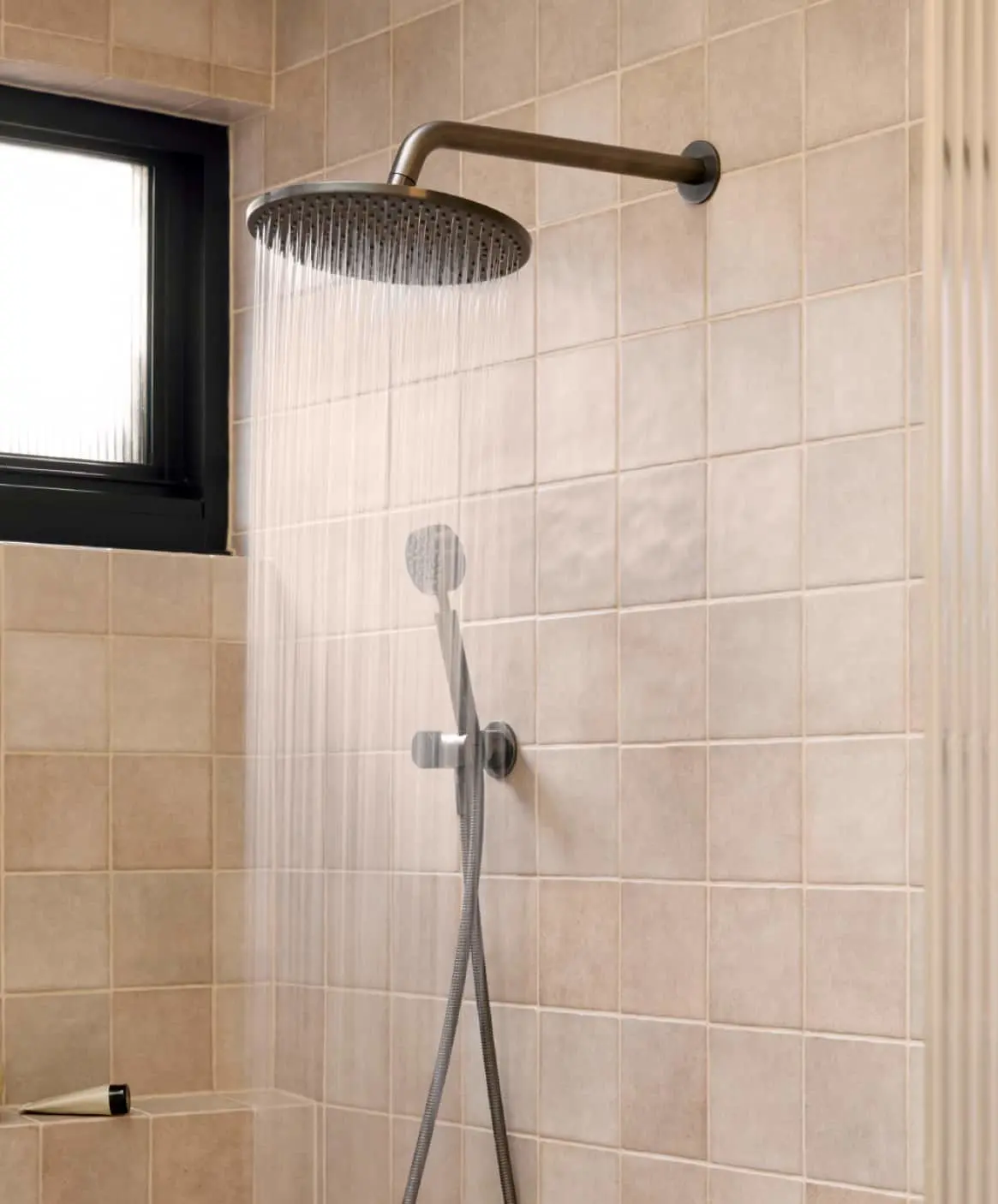 Modern bathroom with beige tiled shower featuring rainfall showerhead.