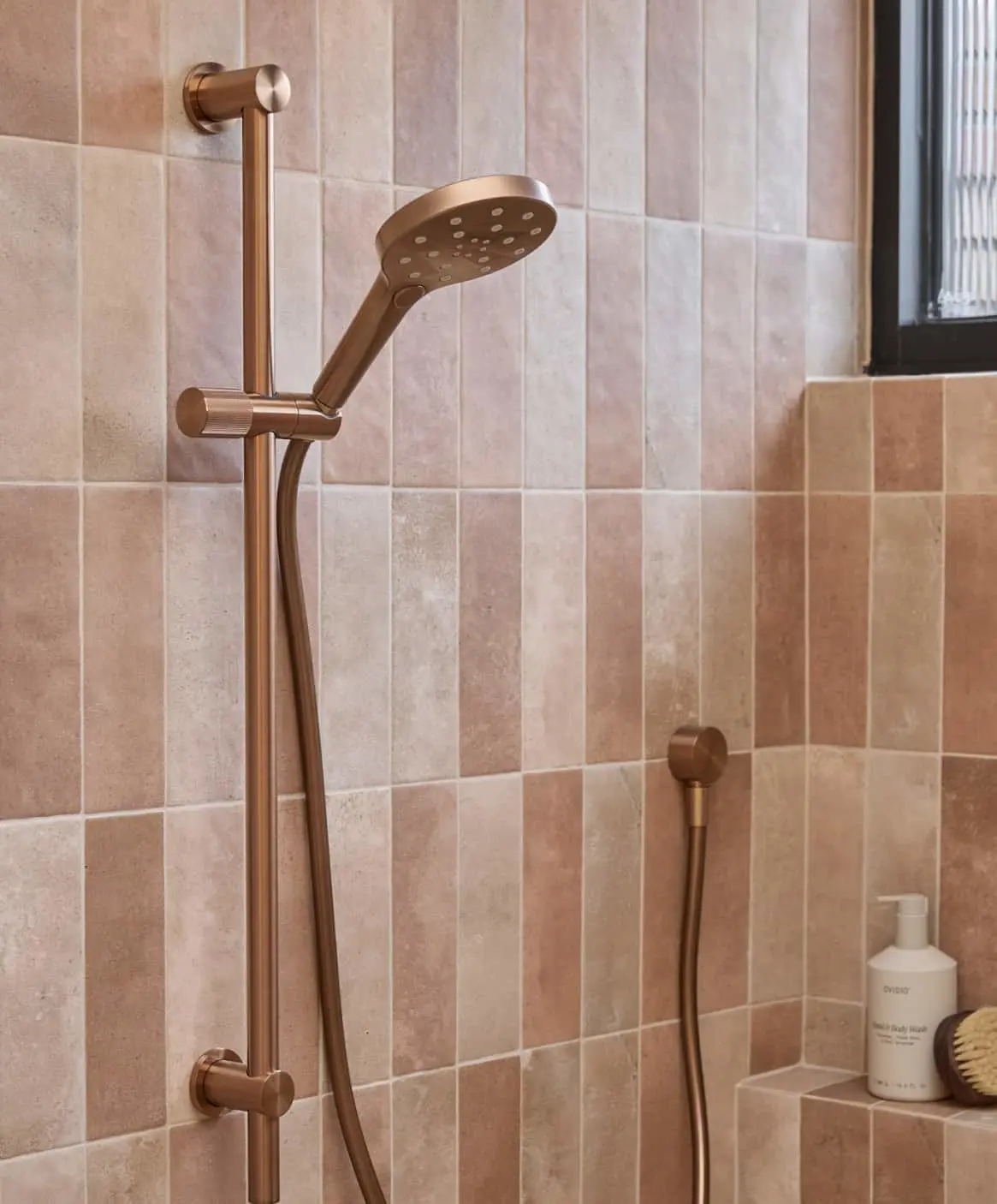 Modern bathroom with bronze handheld shower fixture.