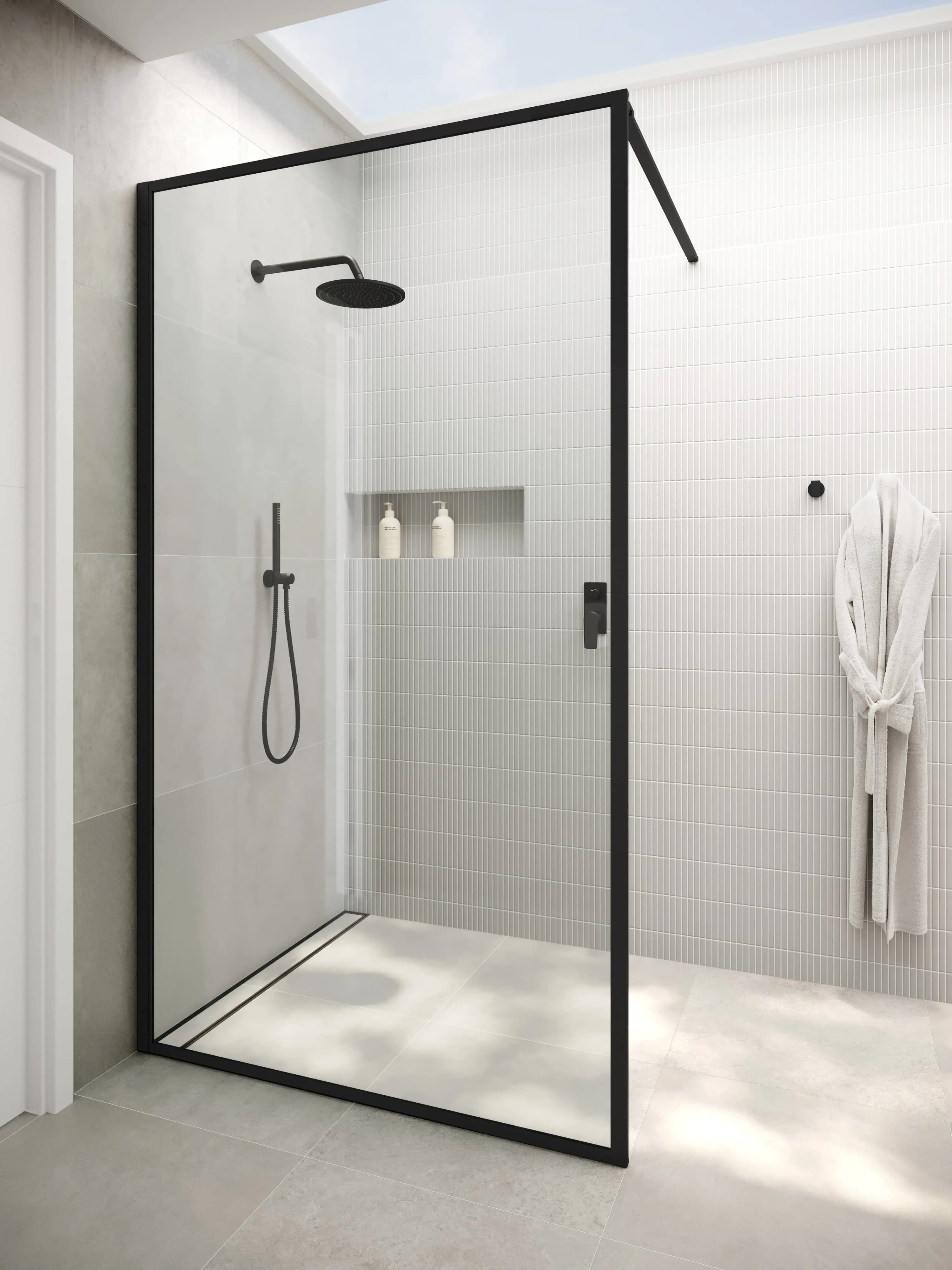 Modern walk-in shower with black frame, white tiled walls, rainfall showerhead, built-in shelf, and white bathrobe hanging nearby.