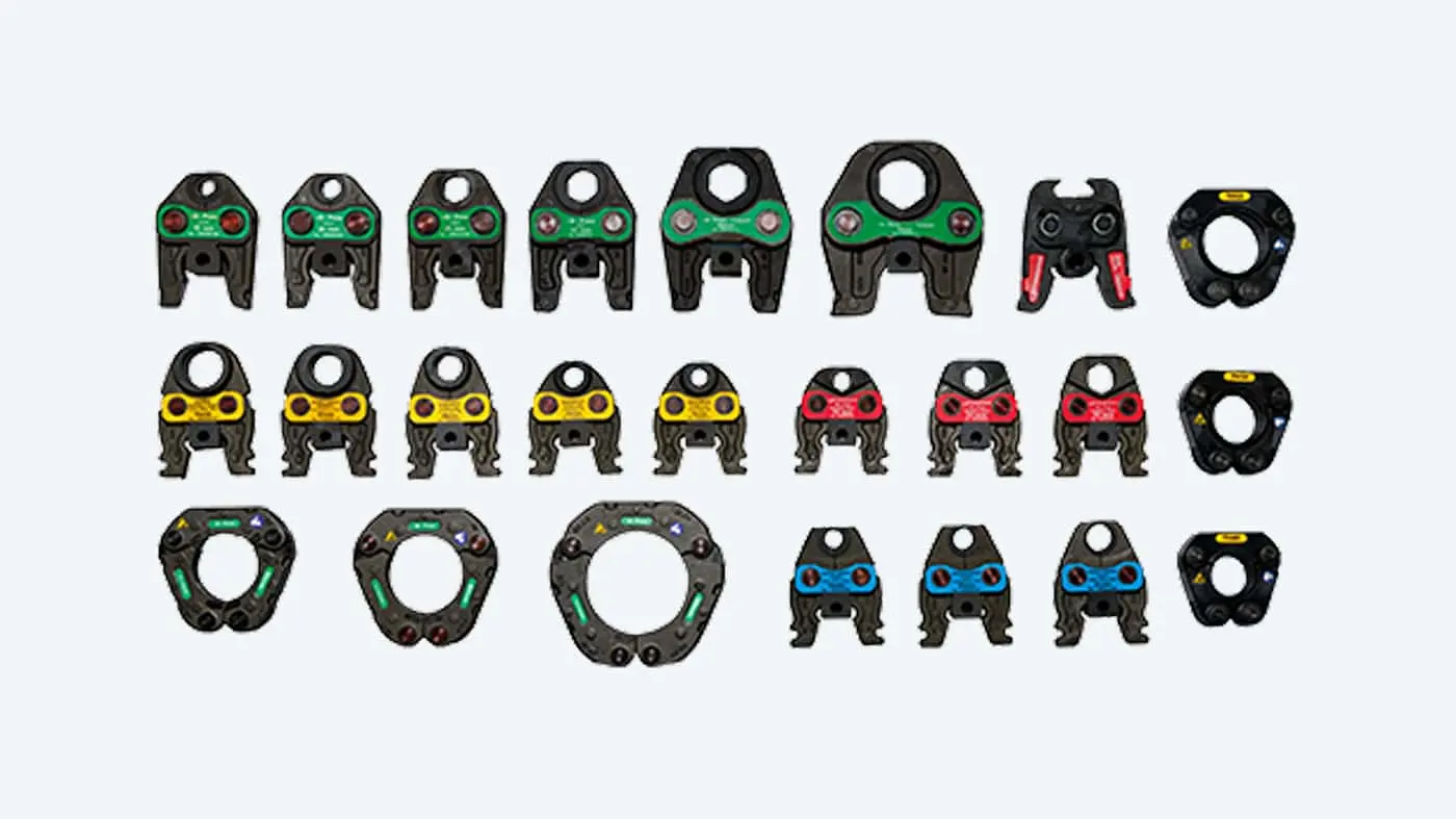 Collection of industrial pipe fittings or crimping tools with colored indicators in green, yellow, red, and blue.