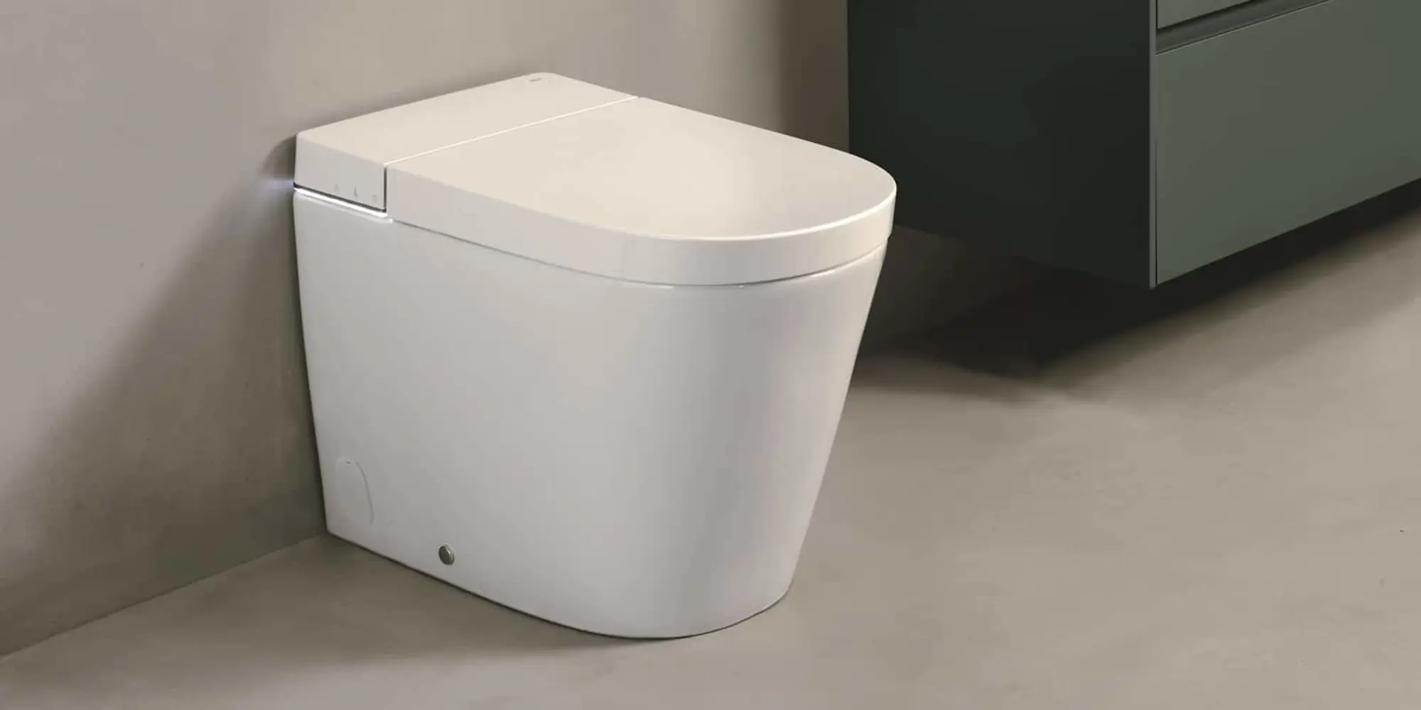 Modern white floor-mounted toilet with electronic bidet seat in a minimalist bathroom with light flooring.