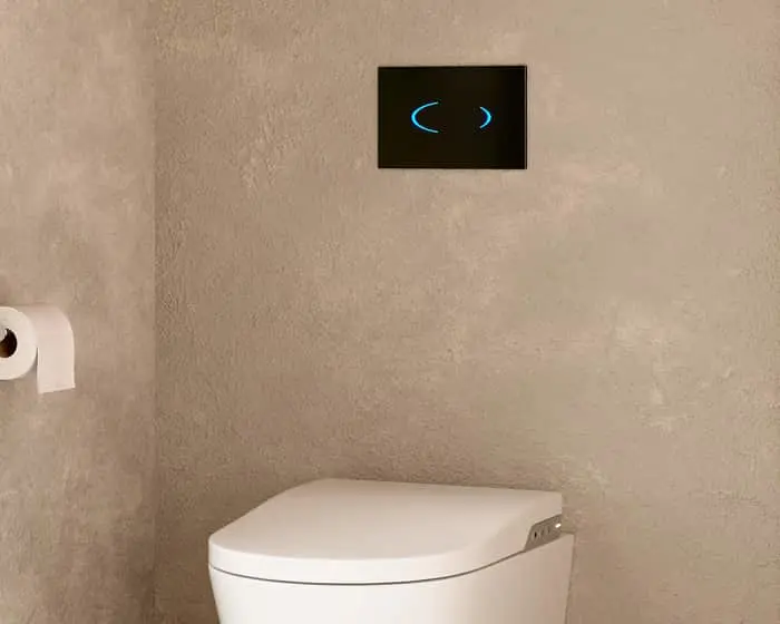 Modern bathroom with white toilet and black digital flush panel with blue illuminated buttons on beige textured wall.