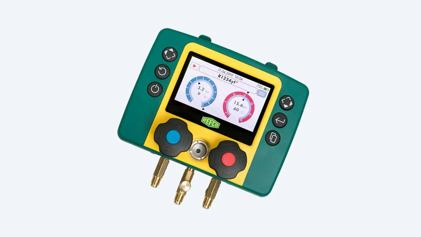 Green and yellow REFCO digital refrigeration gauge with display showing pressure readings and multiple connection ports.