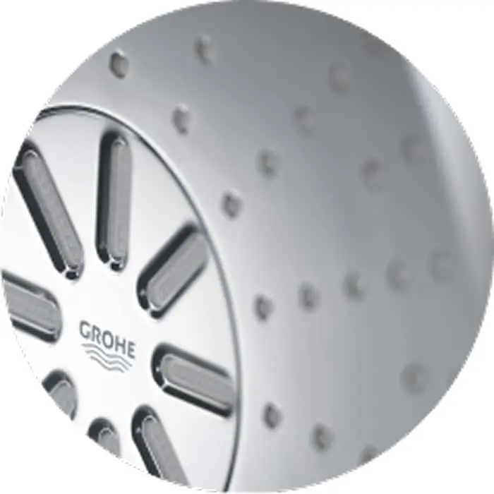 Close-up of a circular GROHE shower head with multiple spray nozzles on a silver metal surface.