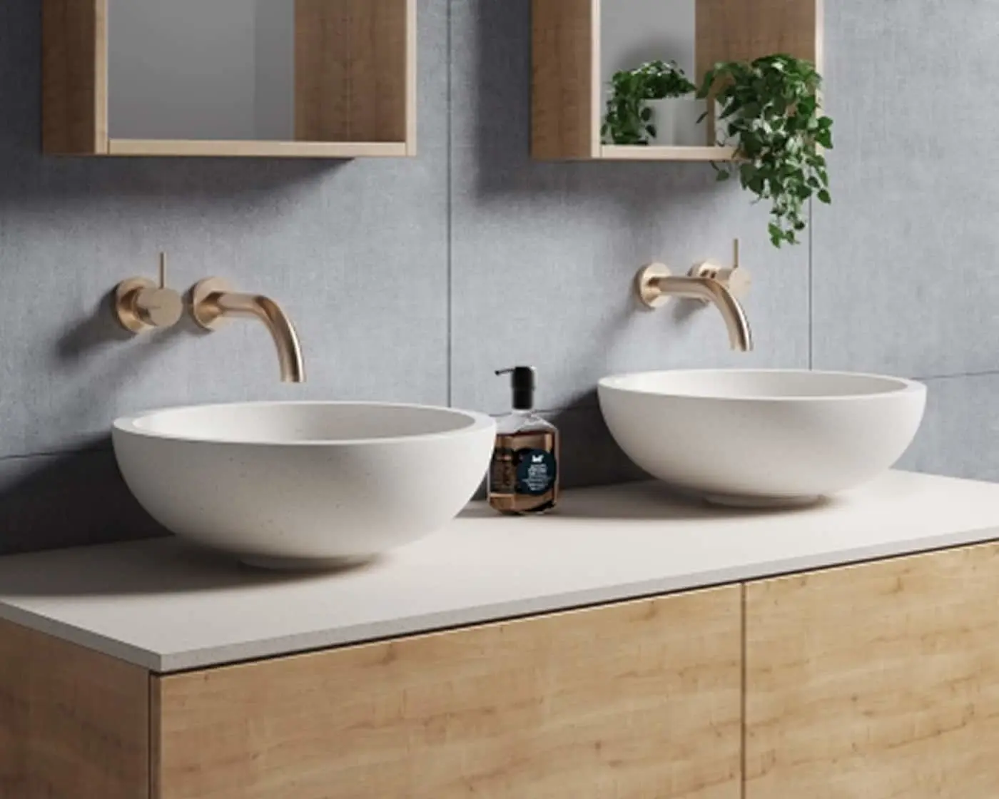 Modern bathroom with two white vessel sinks, brass wall-mounted faucets, wooden vanity, and small plants in wall shelves.