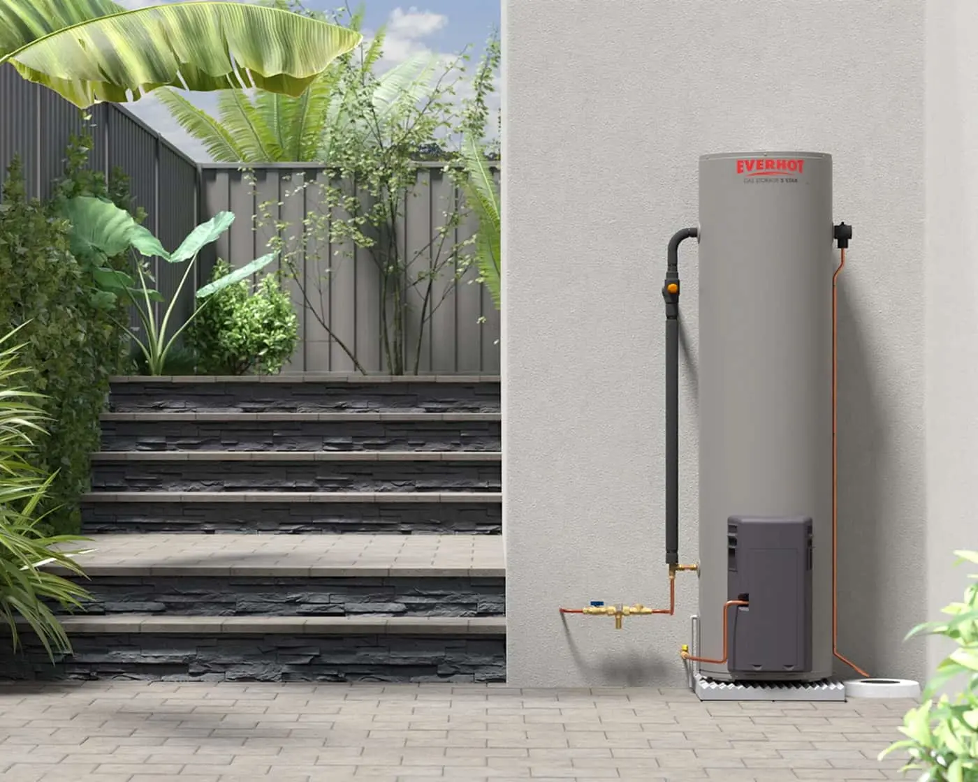 Everhot water heater installed on exterior wall beside garden steps with tropical plants and privacy fence.