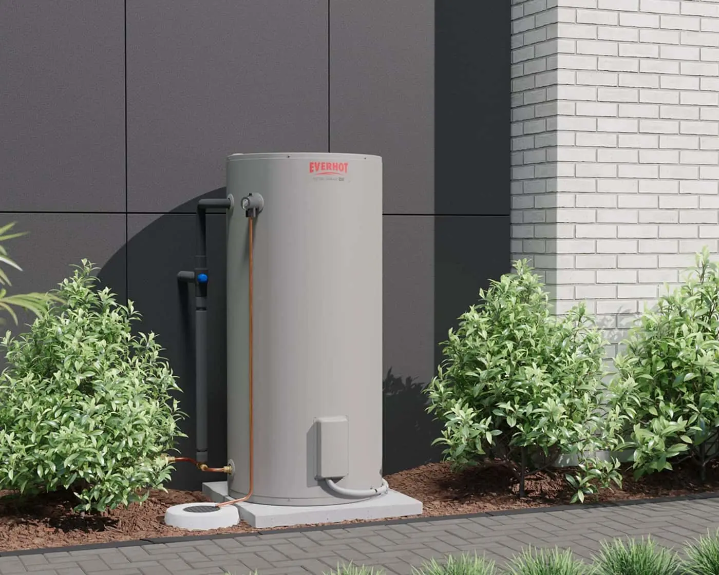Everhot water heater installed outside a modern building with gray panels and white brick, surrounded by green shrubs.