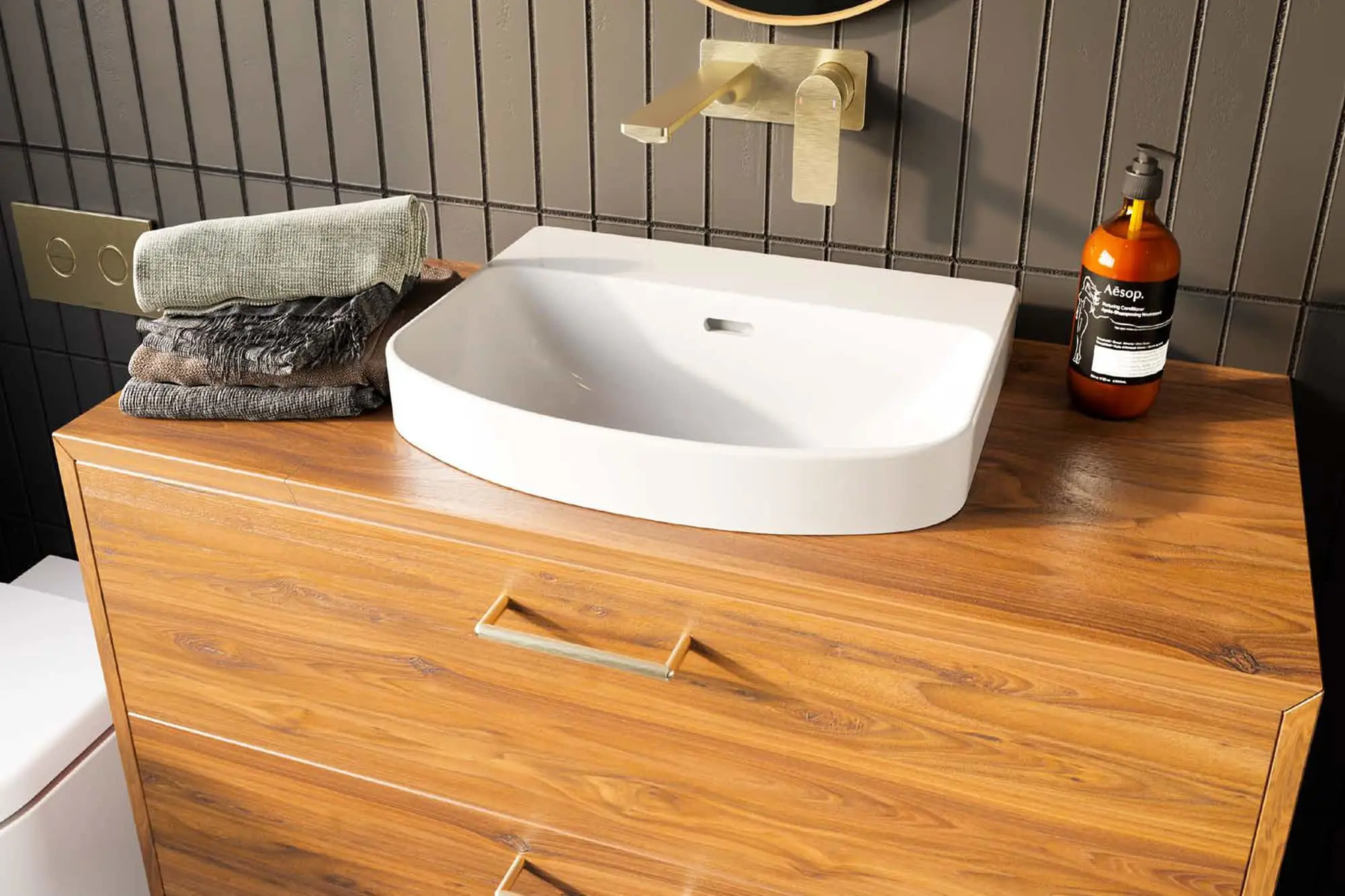 Modern bathroom vanity with white basin sink, brass wall-mounted faucet, folded towels, and Aesop soap on wooden cabinet.