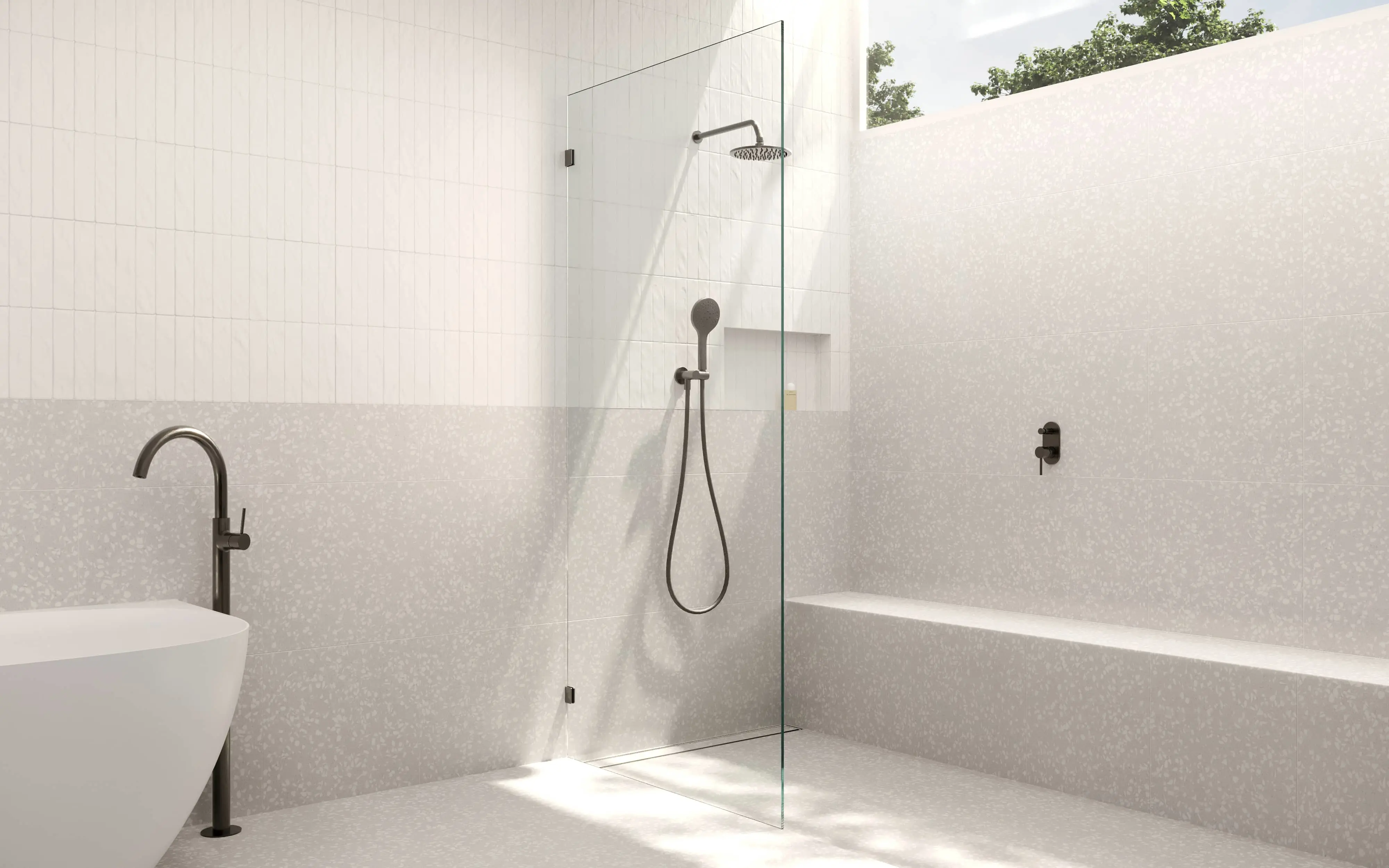 Modern bathroom with glass shower partition, white tiled walls, bronze fixtures, and natural light from skylight.