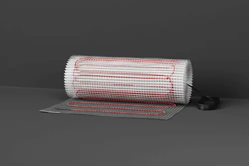 Electric floor heating mat with red wiring partially rolled out on gray background with power connector visible.