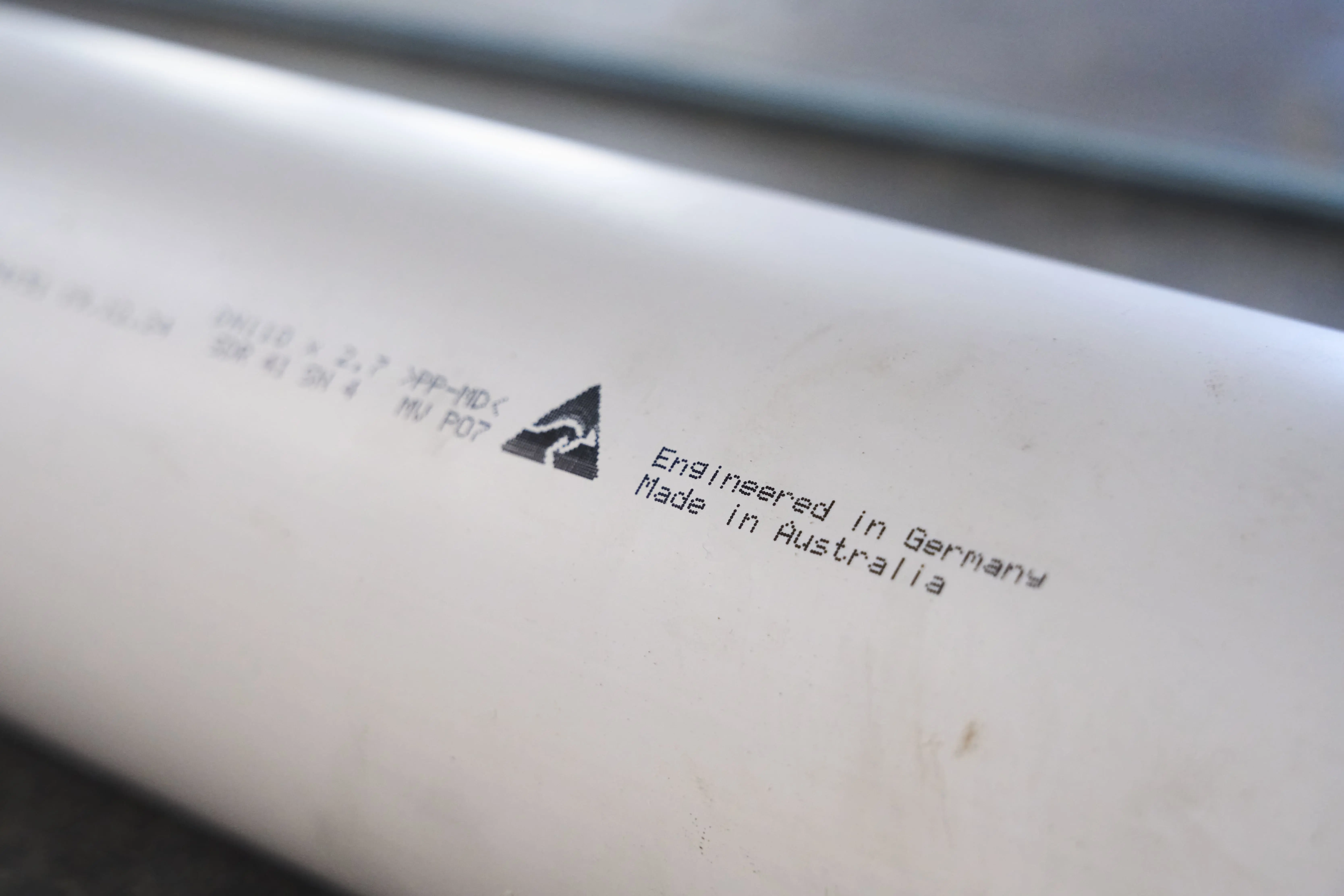 Close-up of product label showing "Engineered in Germany Made in Australia" text with a small logo on white surface.